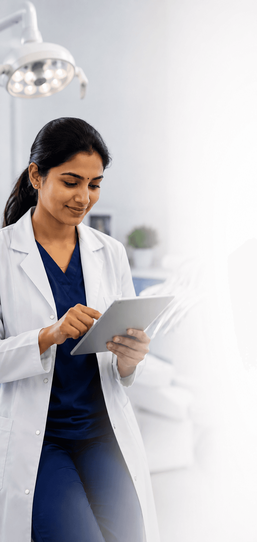 South Indian dentist using tablet in dental clinic